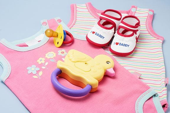 baby products - sandals, pink outfits, colorful pacifier, and yellow duck rattle