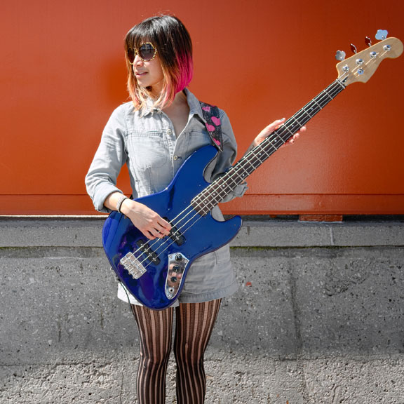 young woman playing a bass guitar