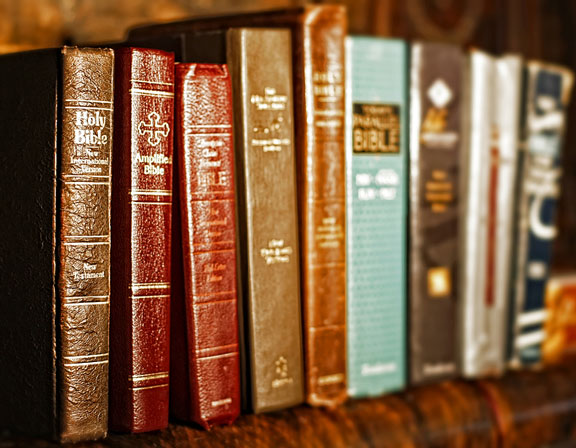 several Bible translations on a shelf