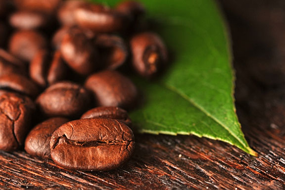 brown coffee beans and green coffee leaf