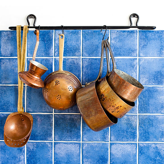 vintage copper cookware on blue tile