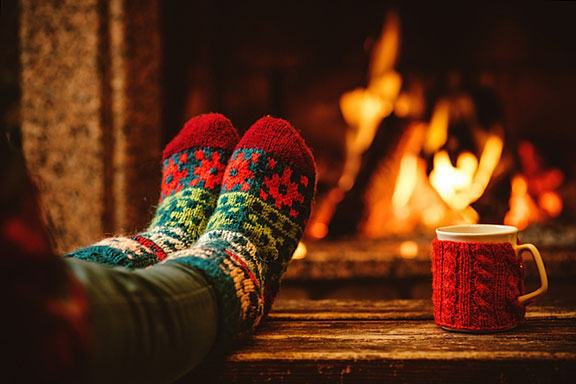 sock-clad feet in front of a toasty fireplace