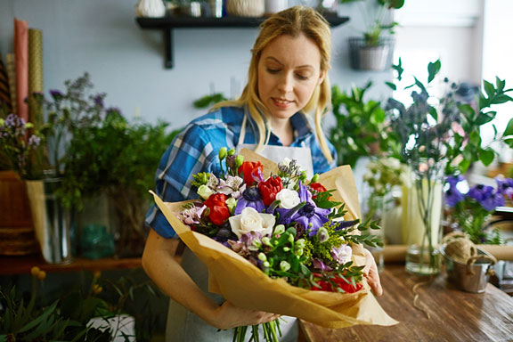 florist holding flower arrangement