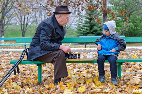 grandfather and grandson playing a chess game