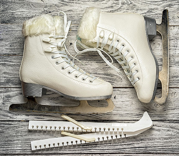 white ice skates on a wooden surface