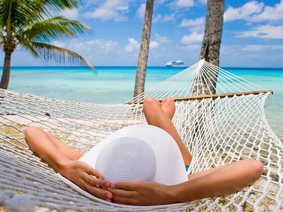 woman relaxing on a hammock under a palm tree