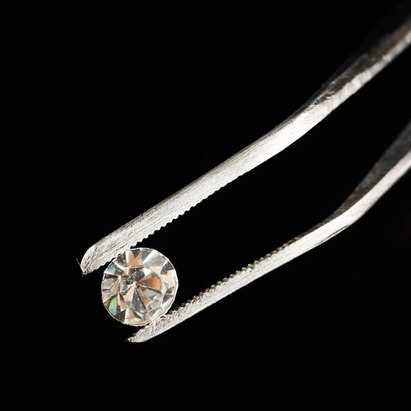 loose diamond held by tweezers