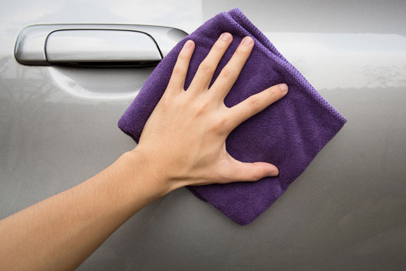 polishing a car door with a cloth