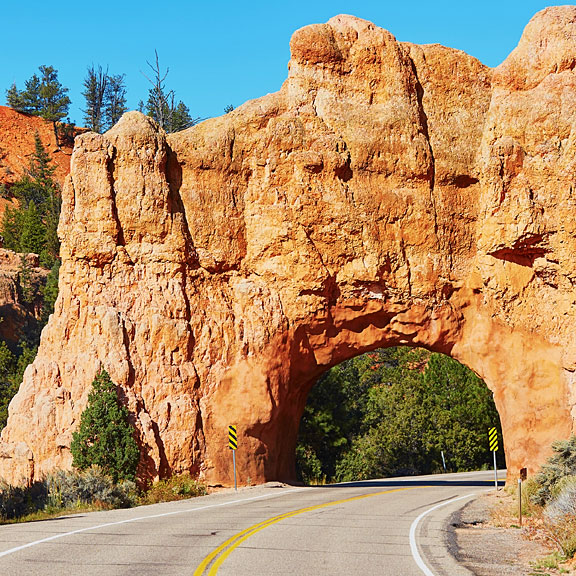 red sandstone bridge over a paved road