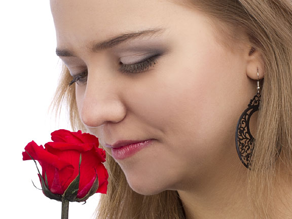 woman enjoying the scent of a rose