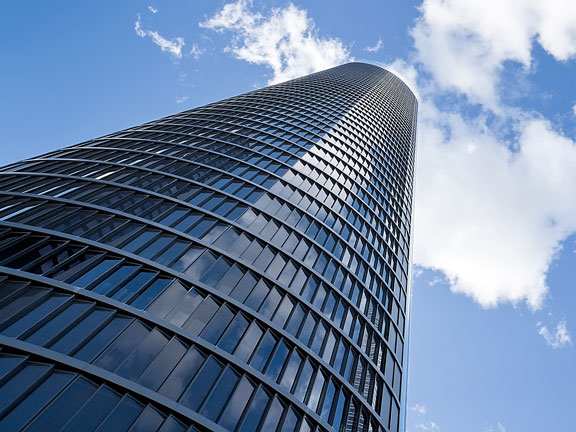 skyscraper against blue sky and white clouds