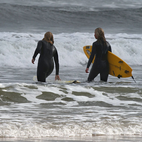 ocean surfers with their surfboards