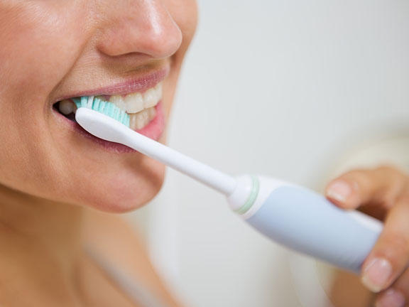 woman using an electric toothbrush