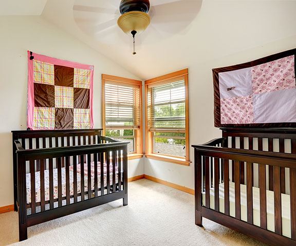 two cribs in a nursery