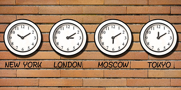 four clocks on a brick wall